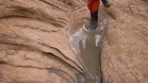 Exploring the serene puddle at the desert rock formation with stunning Stock Footage 288670409
