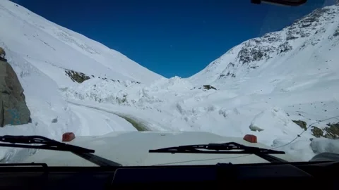 Exploring Shinkula Pass in Snow covered Narrow Path Amidst Towering Mountains Stock Footage 247757178