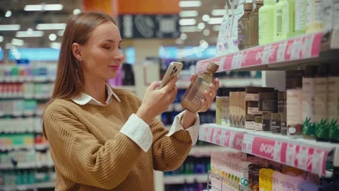 Exploring skincare options at the store while selecting the perfect lotion Vídeos de archivo 293674913