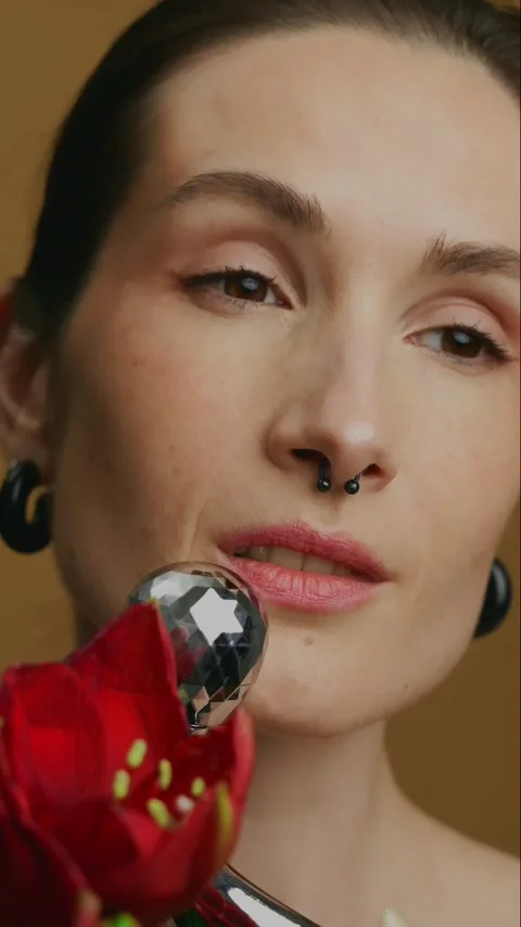 Exploring skincare techniques with facial tools and floral elements 動画素材 305394161