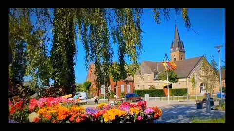 Exploring a small town with flowers and a church in bright sunlight Stock-Footage 347460283