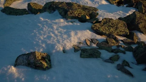 Exploring the snowy landscape with rugged rocks at sunset Stock Footage 290943894