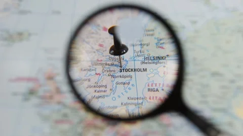 Exploring Stockholm on a paper map with a magnifying glass Stock Footage 340078899