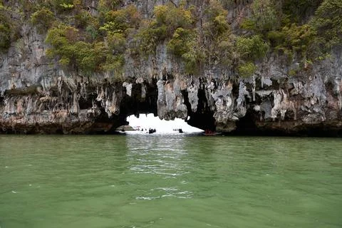 Exploring the Stunning Rock Formations and Emerald Waters of a Coastal Cave.. Stock Photos