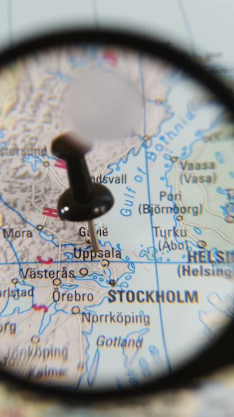 Exploring Uppsala on a paper map with a magnifying glass Stock Footage 340078908
