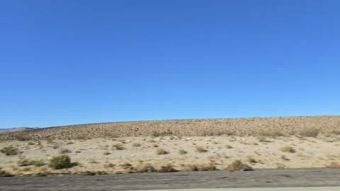Exploring the vast desert landscape under a clear blue sky in the southwestern Stock Footage 296495911