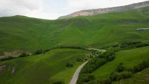 Exploring vibrant green hills and winding roads in a serene landscape Stock Footage 284672378