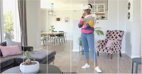 Exploring virtual reality wearing VR headset and striped sweater in living room, Stock Photos