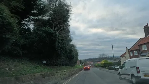 Exploring the winding downhill roads of Whitby town during a scenic drive on a Stock Footage 304814582
