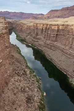 Exploring the winding river amidst towering cliffs in a serene canyon lands.. Stock Photos