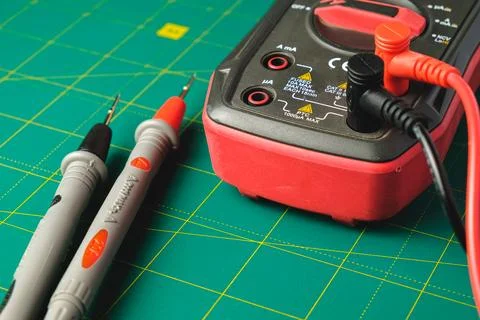 Exploring the world of electronics with a multimeter on a green cutting mat Stock Photos