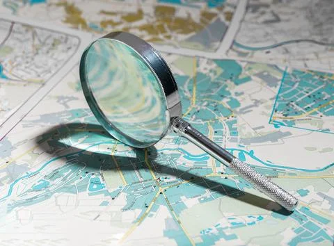 Exploring world map with magnifying glass, planning trips. Zooming in on trav Stock Photos