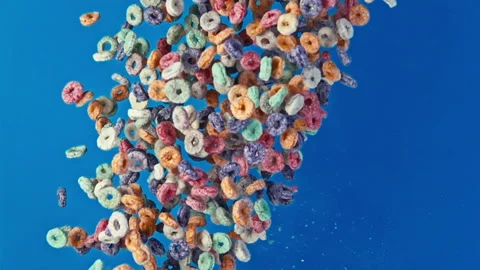Explosion of Colorful Fruit Cereal Loops on Vibrant Blue Background Vídeo Stock 335895038