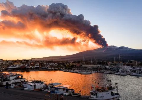 The explosion of Etna forms a large cloud over the port of Riposto. Stock Photos