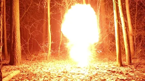 Explosion of a fiery cloud from the darkness.  Bright flash with a fireball. Stock Footage 83040947