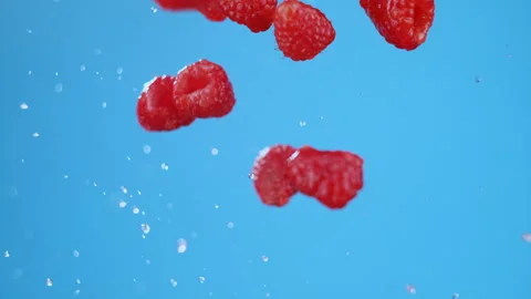 Explosion on fresh raspberries with water, flying in air after launch. Stock Footage 279529036