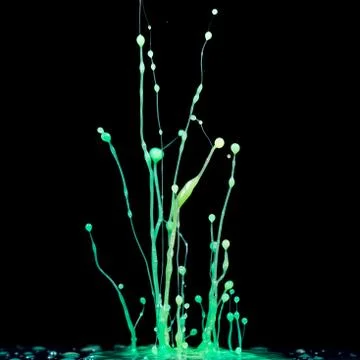 Explosion of splashes and bursts of colour fluid paint or ink on a black back Stock Photos