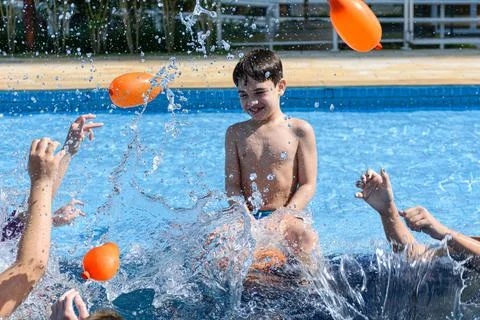Explosion of water. Defocused in the background, smiling 8 year old child sit Stock Photos