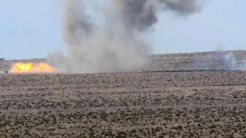 Explosions in an open field of a desert Stock Footage 109575421