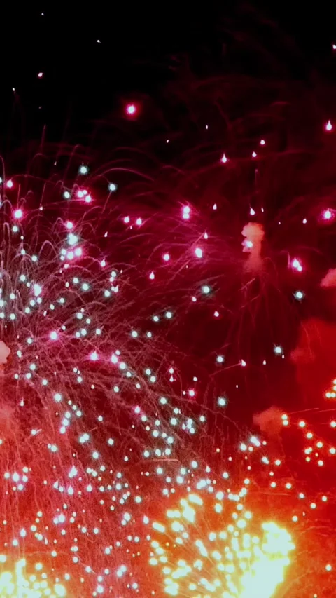 Explosive colors burst in the night sky over a vibrant festival celebration Video stock 295937246