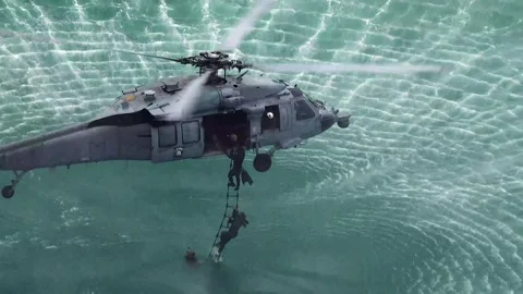 Explosive Ordnance Disposal technicians ascending ladder into SH-60 Seahawk Stock Footage 279729154