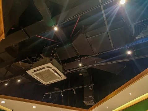 Exposed black industrial ceiling with a square cassette air conditioning un.. Stock Photos