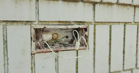 Exposed dangerous electrical wiring inside rusty junction box on wall Stock Footage 335600128