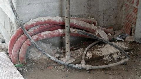 Exposed electrical conduits and cables at construction site interior Stock Photos