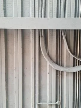 Exposed electrical conduits and cables on industrial wall. Building infrast.. 스톡 사진