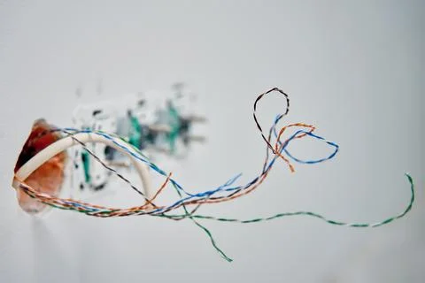 Exposed network cables in wall socket during repair Stock Photos
