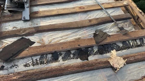 Exposed roof structure with damaged shingles and weathered wooden battens Stock Footage 346757221