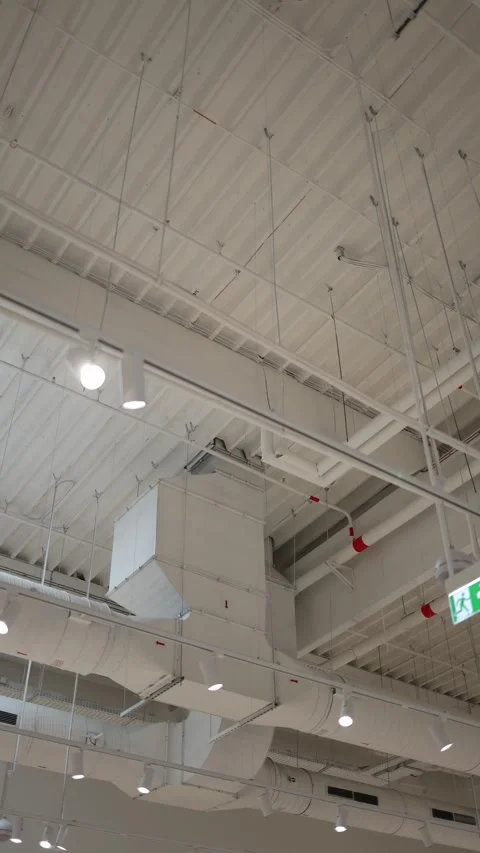 Exposed ventilation ducts and pipes across modern commercial ceiling Stock Footage 342912225