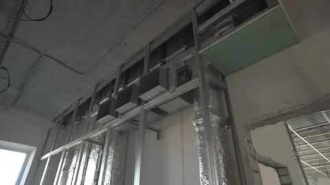 Exposed ventilation ducts snake along raw interior wall 動画素材 310602890
