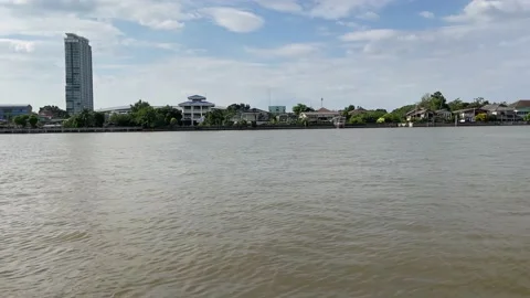 Express Boat sails on Chao Phraya River during daytime see buildings and homes Video stock 171258127