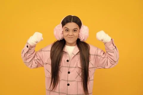 Express emotion. winter fashion. angry kid in fur earmuffs showing fists. Stock Photos