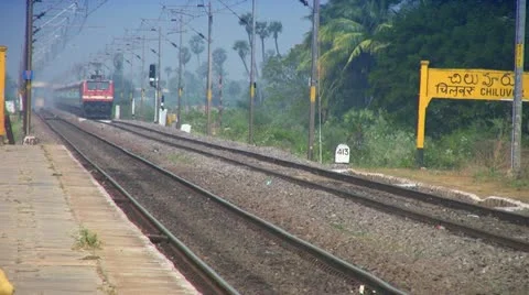 Express passenger train speeds through station in India Stock Footage 21254234