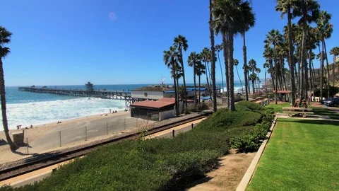 Express train pulls through San Clemente Pier station. Camera pans on last Video stock 95493255