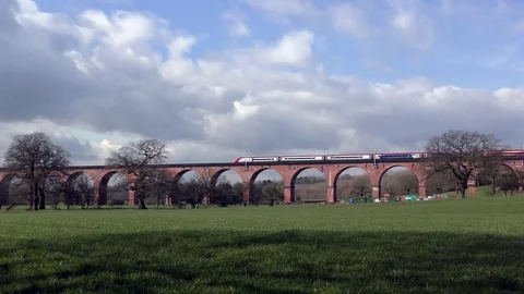 Express train slowly over viaduct countryside moody sky Stock Footage 72772444