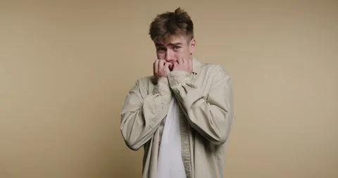 Expressing fear with hands covering face in a cozy room, showcasing emotion.. Vídeo Stock 329113014