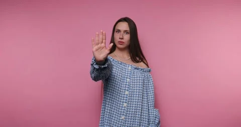 Expressing feelings through gestures in a bright pink setting with a young .. Stock Footage 317397078