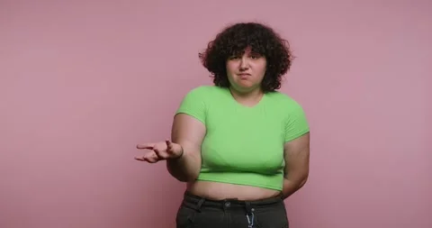 Expressing feelings through gestures in a pink background with a woman in a.. 스톡 동영상 331990752