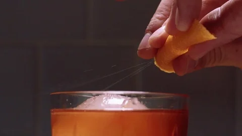 Expressing an orange peel on an old fashioned Stock Footage 83862602