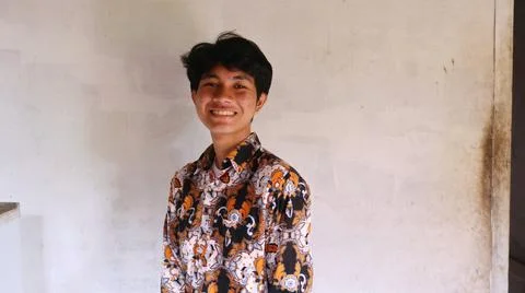 The expression of an Asian man wearing typical Indonesian batik clothes wit.. 写真素材