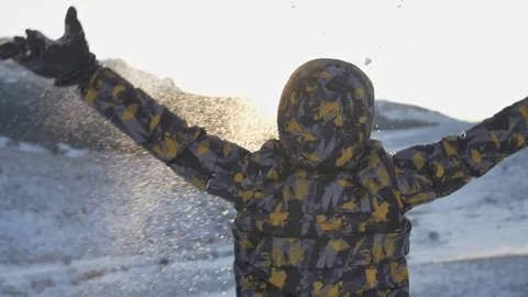 Expression of childish joy. A child throws snow with his hands against the backg Stock Footage 151154157