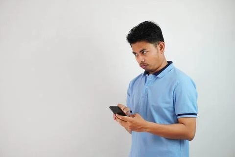 Expression of dislike trying to dodge with holding phone young asian man we.. Stock Photos