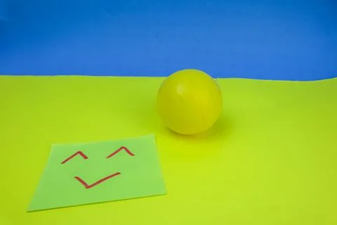 An expression drawn on a sticky note accompanied by a yellow ball on a lime a Stock Photos
