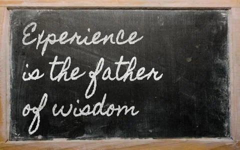 Expression -  experience is the father of wisdom - written on a school blackb Stock Photos