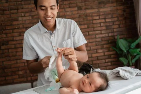 Expression of father when change diapers for the baby's Stock Photos