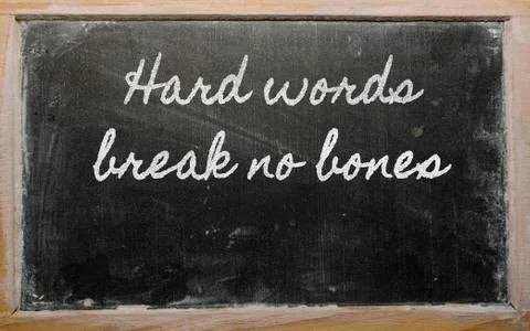 Expression -  hard words break no bones - written on a school blackboard with Stock Photos