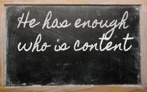 Expression -  he has enough who is content - written on a school blackboard w Stock Photos